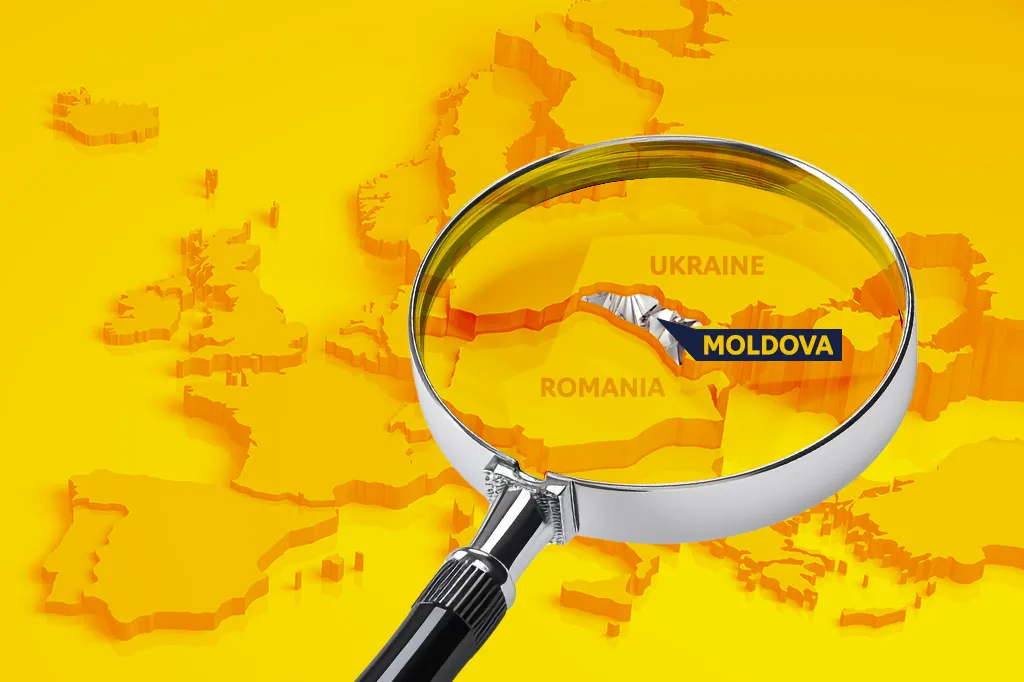 Een vergrootglas boven een gele reliëfkaart van Europa licht Moldavië tussen Roemenië en Oekraïne uit.