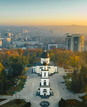 Luchtfoto van Chișinău bij zonsopgang met de witte kathedraal en het park in herfstkleuren